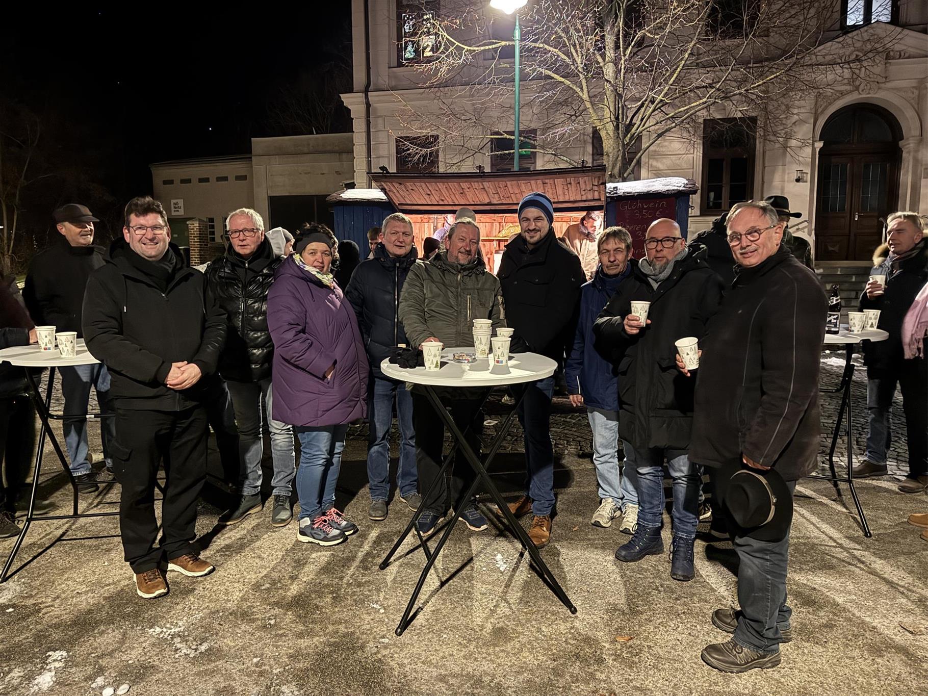 Vor dem SKW Punschstand stehen Werner Bischof, Christian Höfinger, Annemarie Maurer, Markus Semmelmeyer, Peter Trattnig, Stefan Vietze, Robert Samsinger, Matthias Brauneis, Richard Hogl